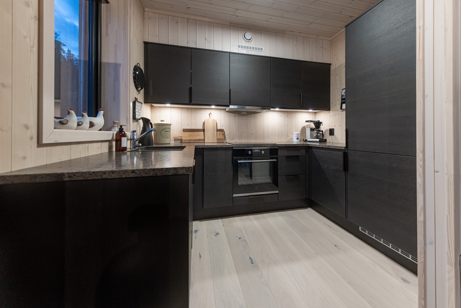 Kjøkkenet har en delvis åpen løsning mot stuen med lett adkomst til spisebord Galleribilde