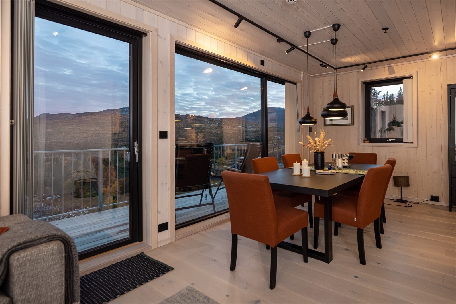 Fra stuen er det utgang til leilighetens balkong. De store vinduene sikrer godt lysinnslipp og utsyn mot den norske fjellheimen Galleribilde