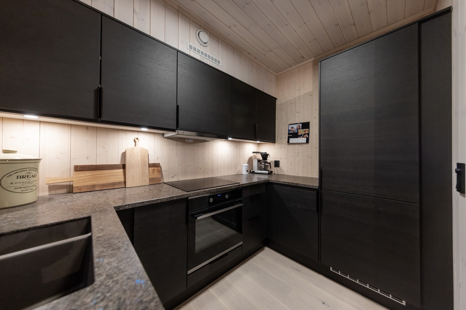 Stilren kjøkkeninnredning med mye skap- og benkeplass Galleribilde