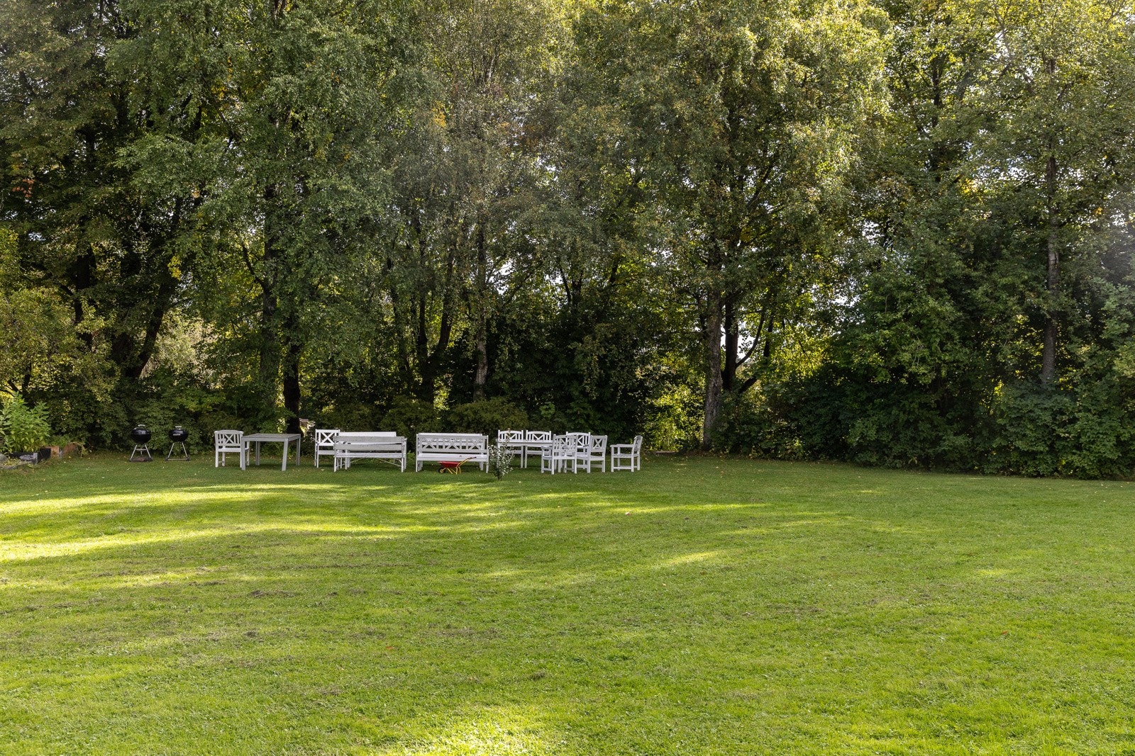 Flere felles sittebenker legger tilrette for sosial hygge i bakhagen. I tillegg er det satt ut felles grill. Galleribilde