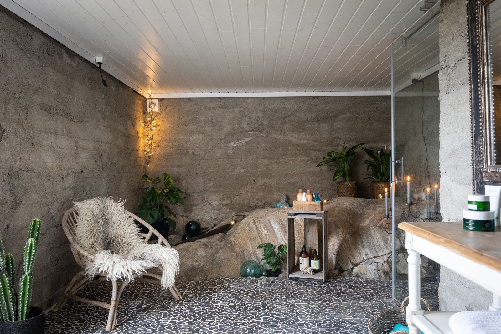 Badet har fliser på betong, ubehandlet betong på vegger og fjell i dagen. Galleribilde