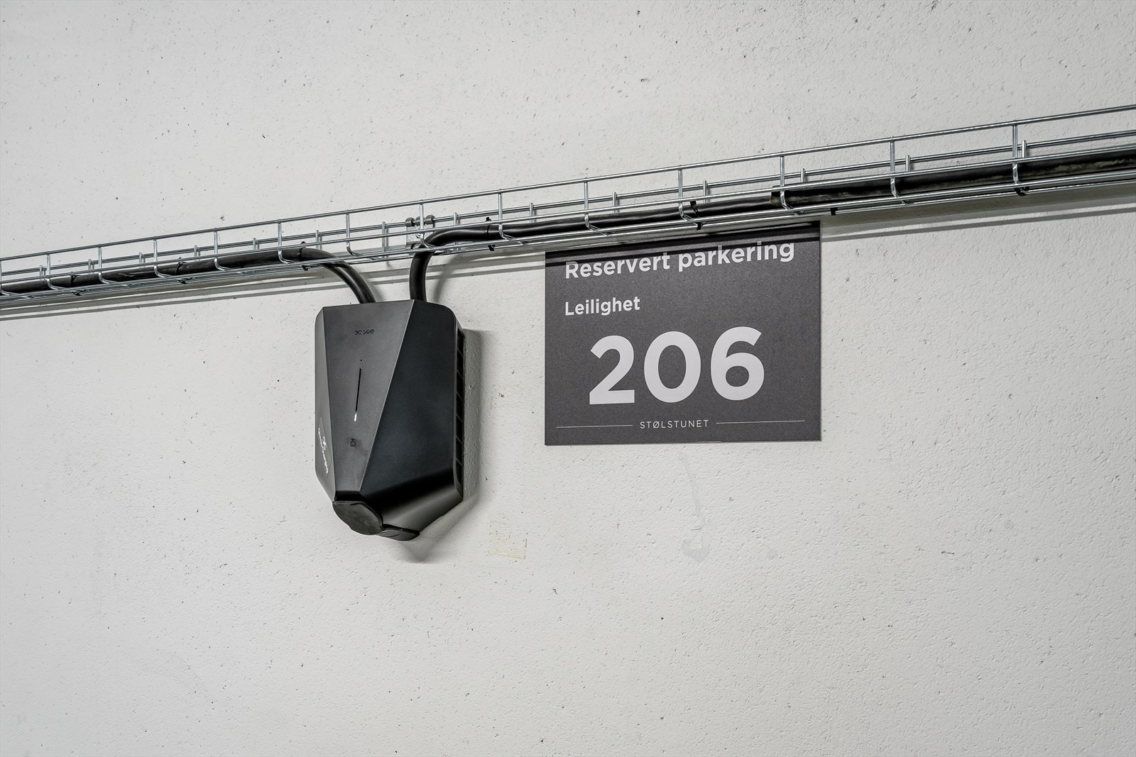 Ladepunkt for elbil og ladbar hybridbil i tilknytning til parkeringsplassen. Galleribilde