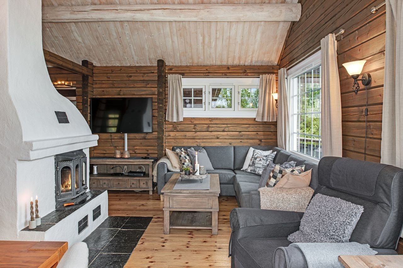 Meget koselig stue med høy og luftig takhøyde, peis og lune tømmervegger Galleribilde