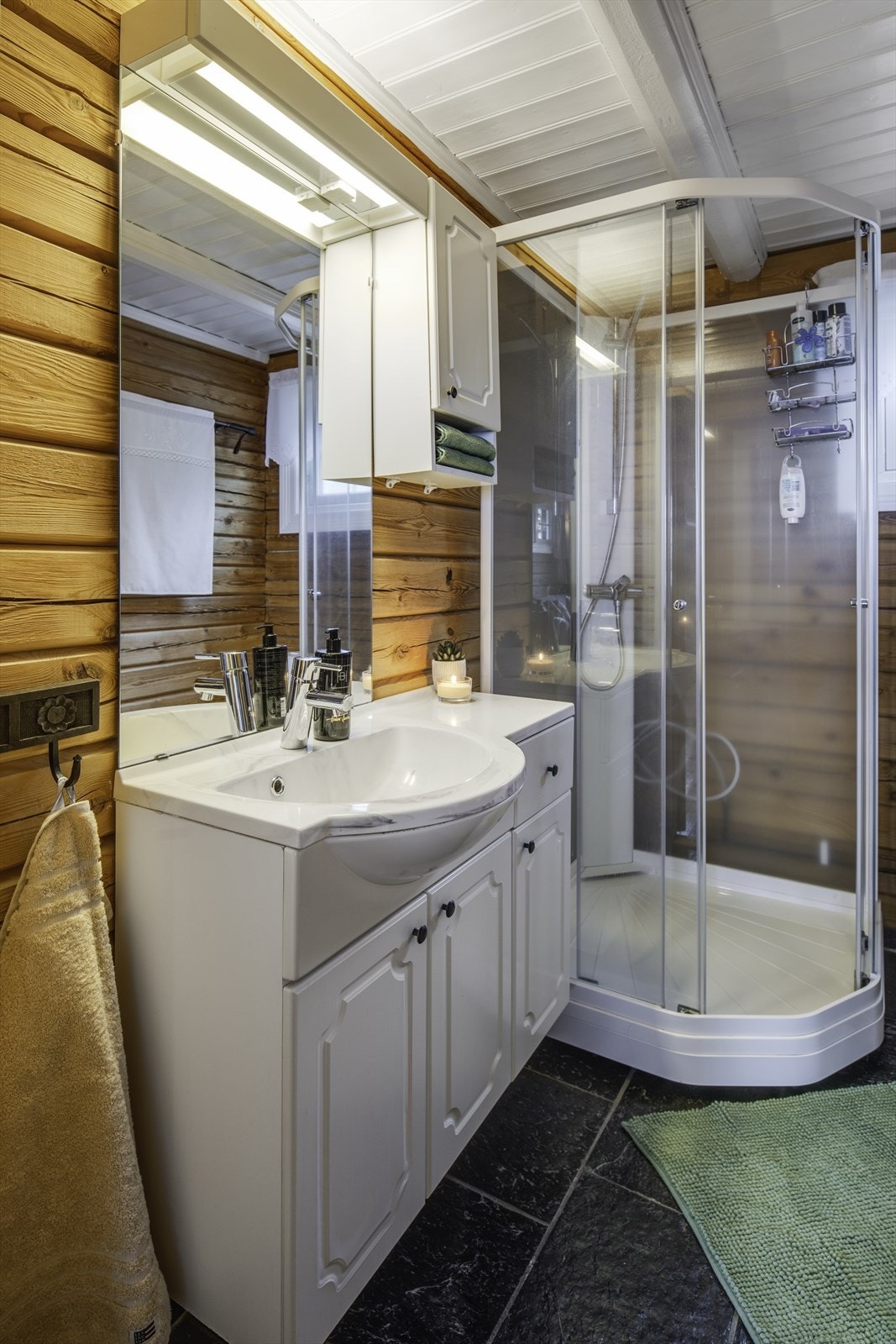 Bad med dusjkabinett, servant innfelt i baderomsinnredning og gulvmontert toalett Galleribilde