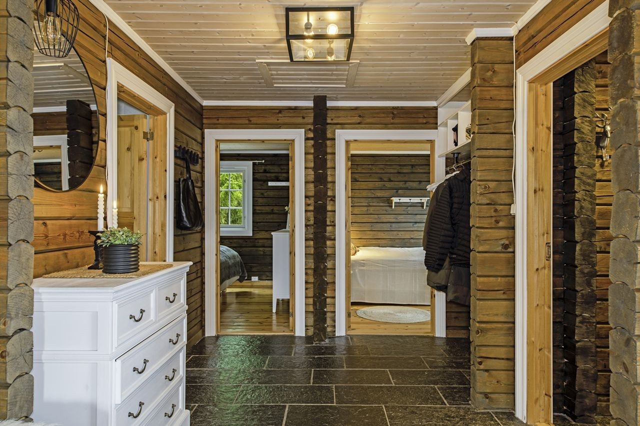 Romslig flislagt gang med varmekabler i gulvet. Adkomst til 3 soverom, bad og entrè. Nisje til yttertøy og sko Galleribilde