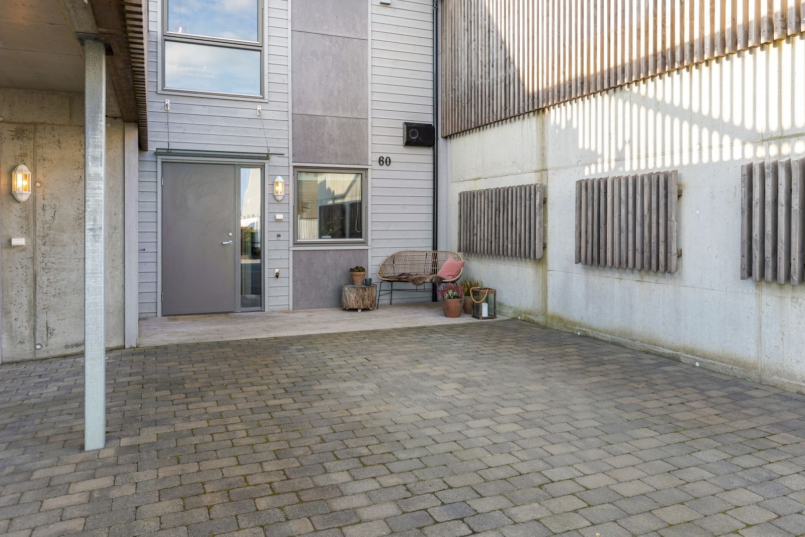 Inngangsparti og steinbelagt gårdsplass og carport. Galleribilde