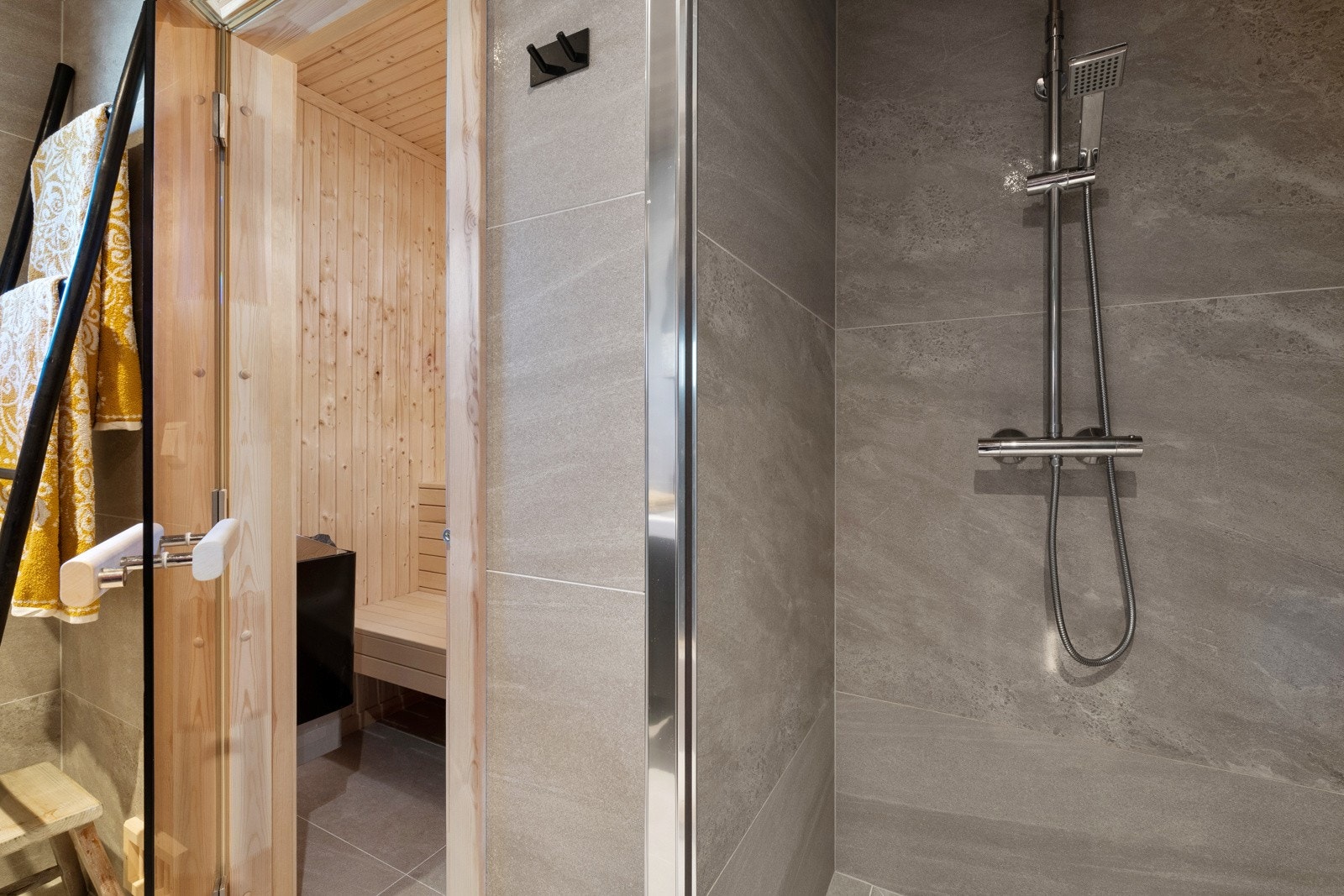 Videre har badet gulvmontert toalett og dusjnisje med glassdør, regnfallsdusj og hånddusj. Galleribilde