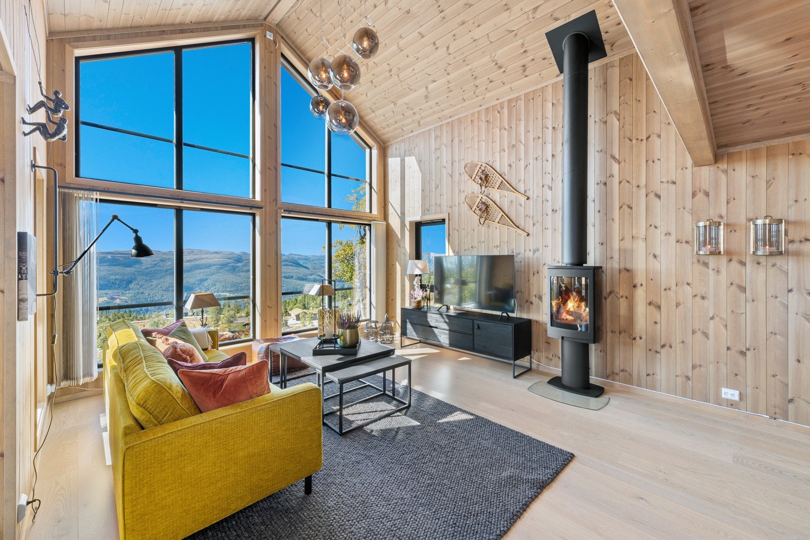 Hytta har en stor, praktfull stue med mønet tak og vinduer langs hele fasaden som byr på storslagen utsikt over fjellheimen ? mer idyllisk enn dette får du det knapt. Galleribilde