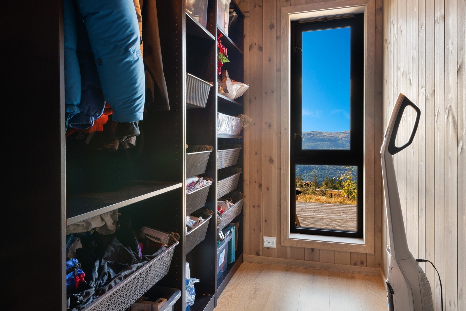 Ett av rommene benyttes til garderoberom og har åpen garderobeløsning med kurvsystem, hyller og heng Galleribilde