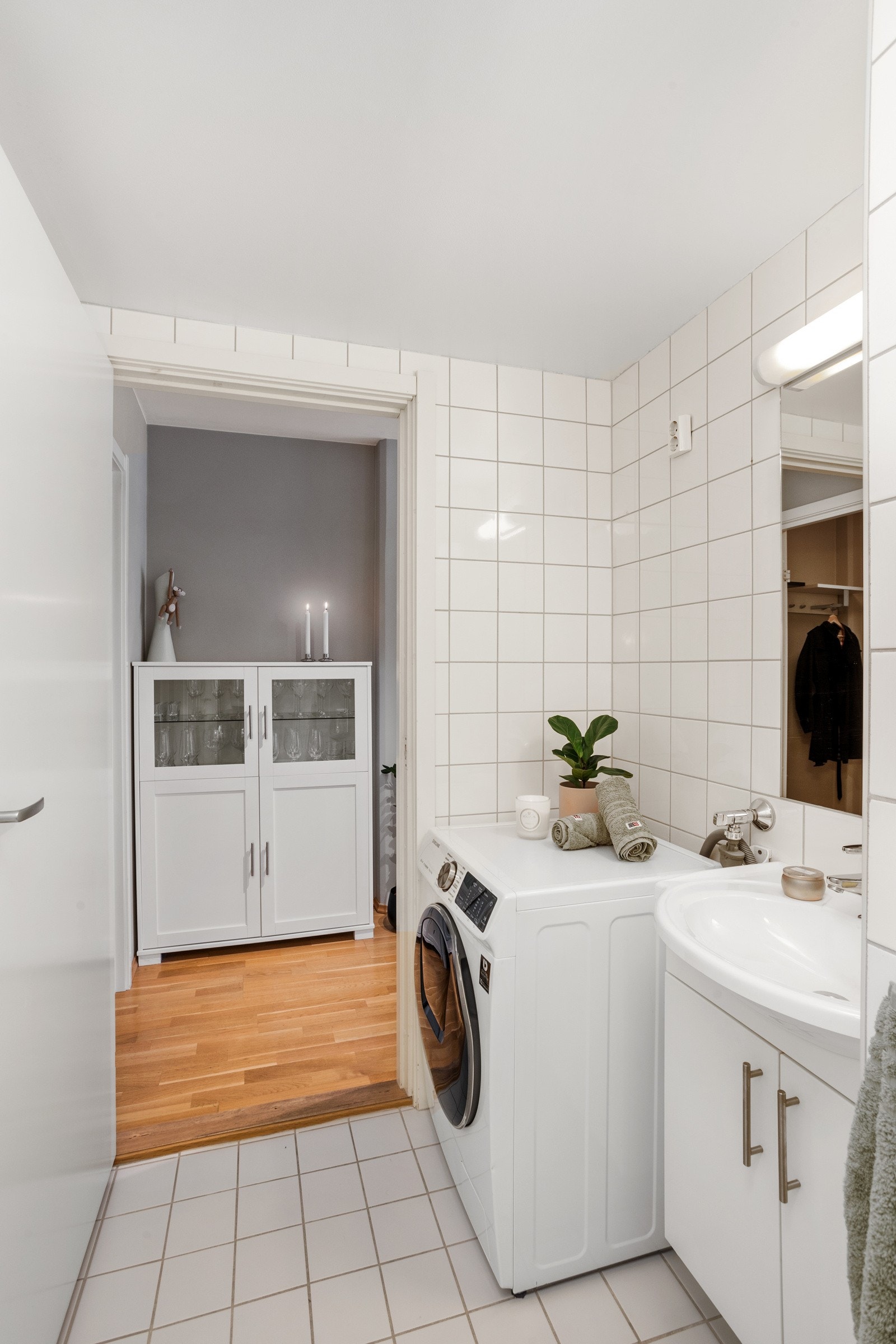 Baderommet holder et tidløst design med hvite, flislagte overflater på gulv og vegger. Galleribilde