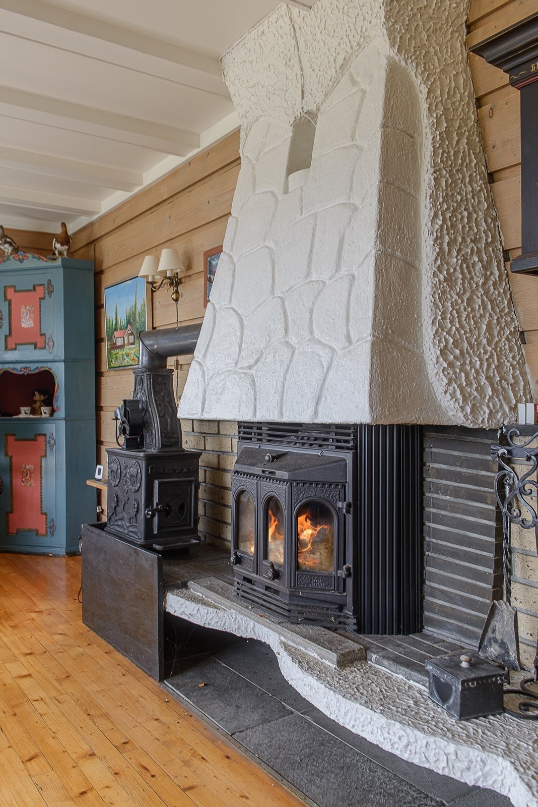 Rommet har en stor lukket peis som gir godt med varme på kaldere dager Galleribilde