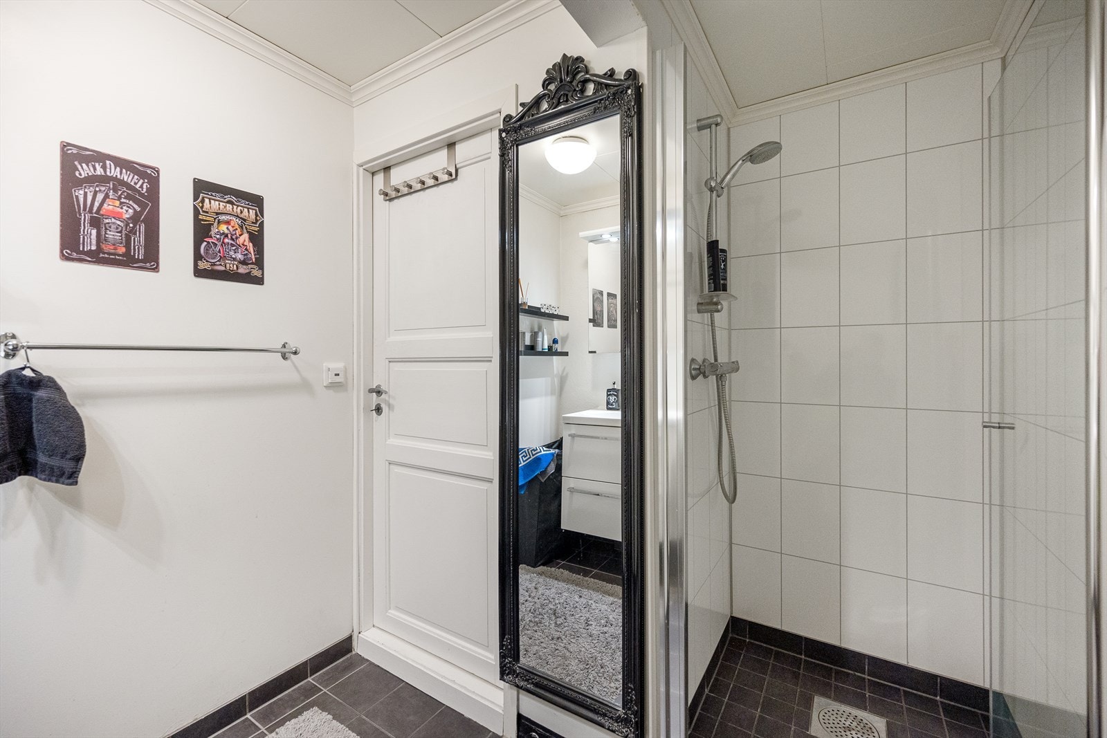 Badet er innredet med dusj, toalett, servant med skuffeseksjon og speil Galleribilde