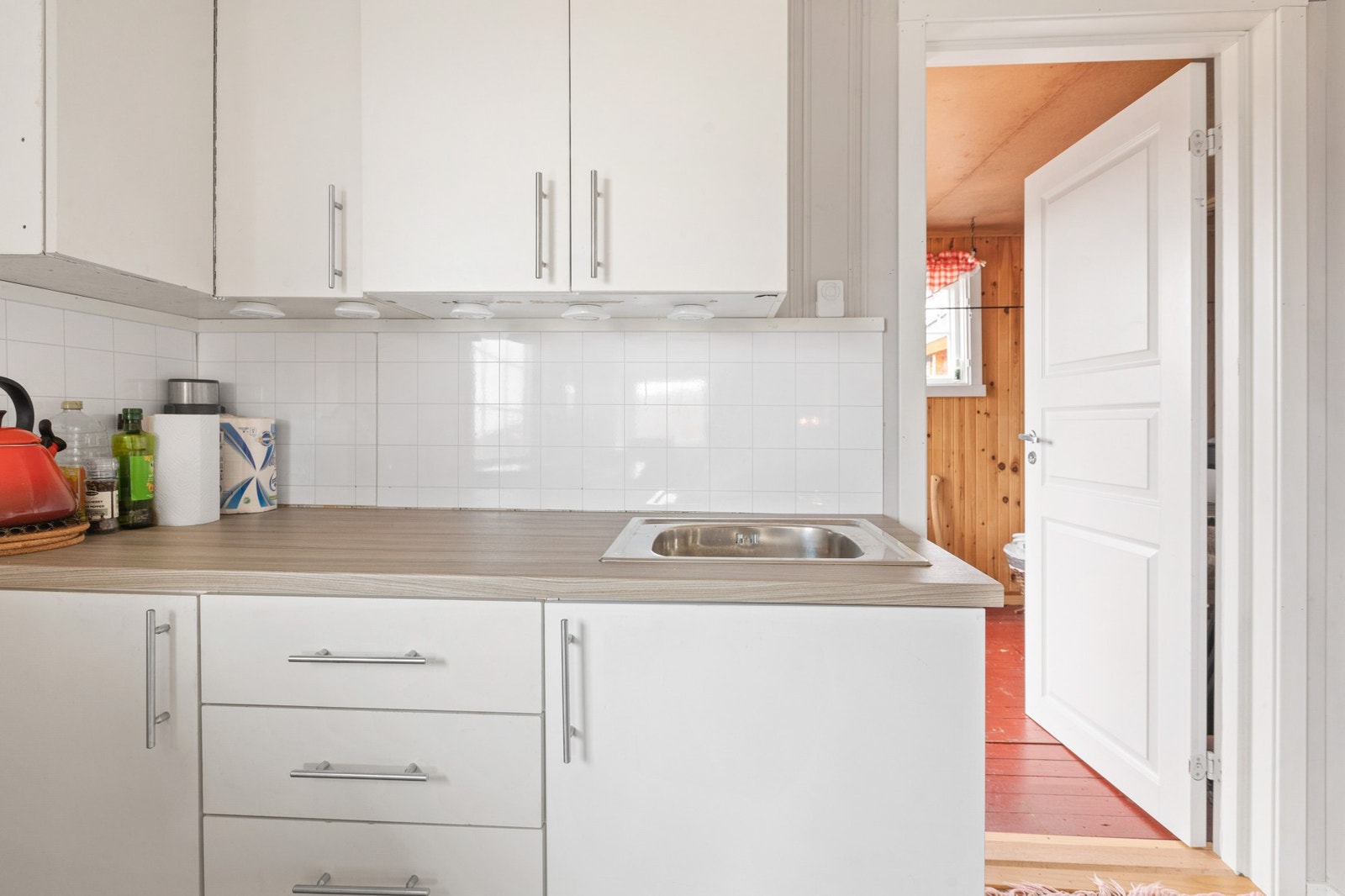 Kjøkkeninnredningen har lyse fronter og benkeplate med nedfeldt kum Galleribilde