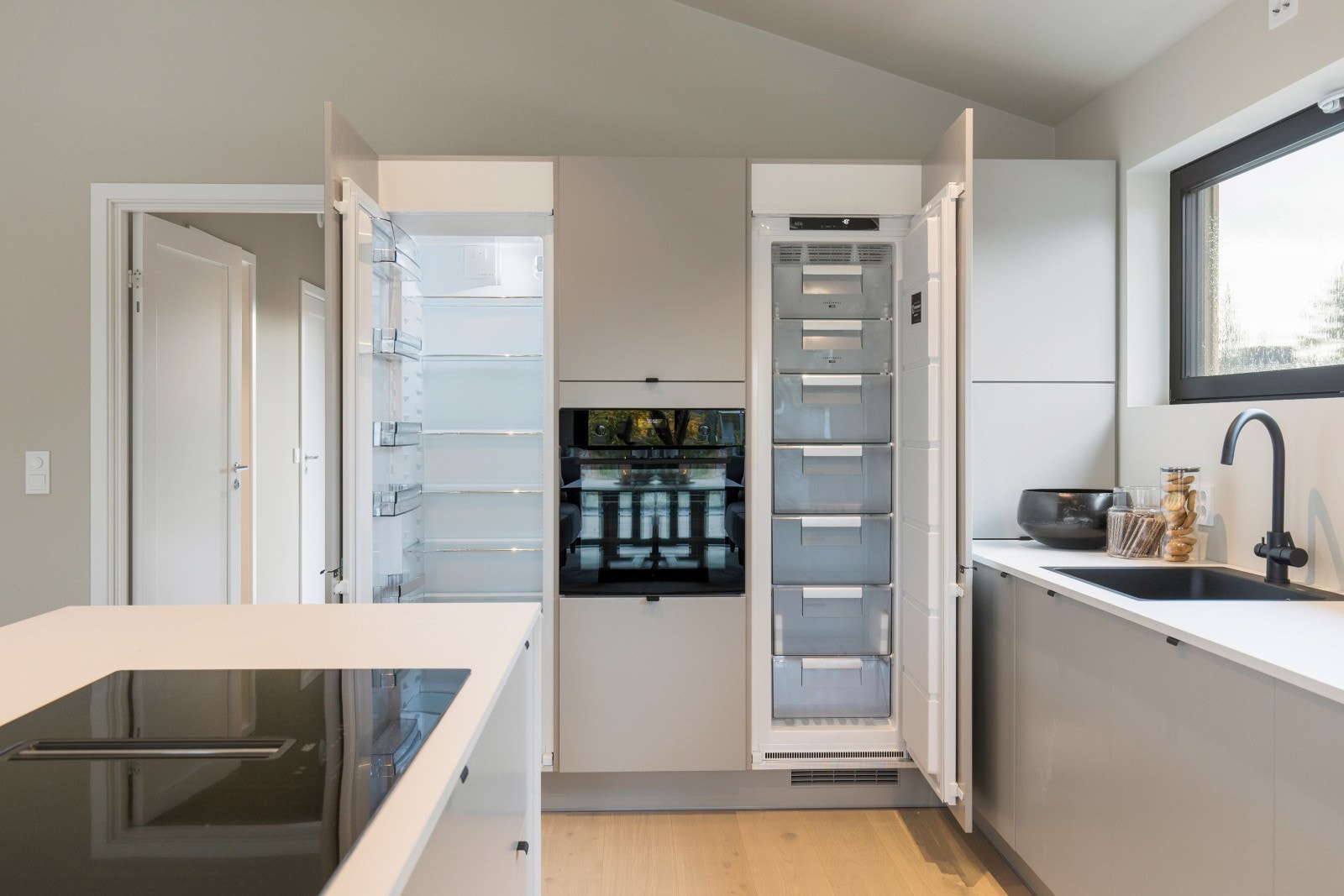 God plass for oppbevaring i hel kjøl-/fryseskap. Downdraft ventilator i koketopp gir et minimalistisk preg. Galleribilde