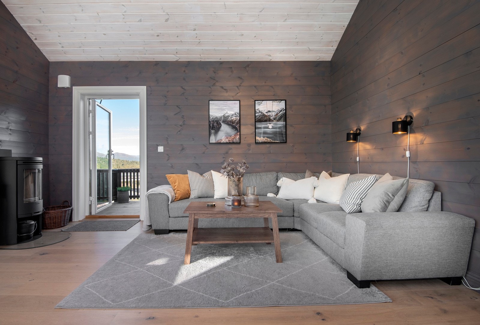 Det er god plass til sofagruppe på stuen. Peisovn med glass. Utgang til veranda. Galleribilde