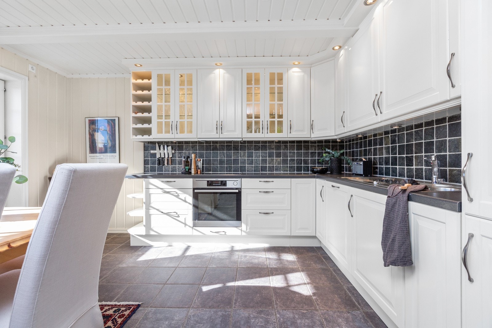 Kjøkkenet har innredning med over- og underskap med profilerte, lyse fronter Galleribilde