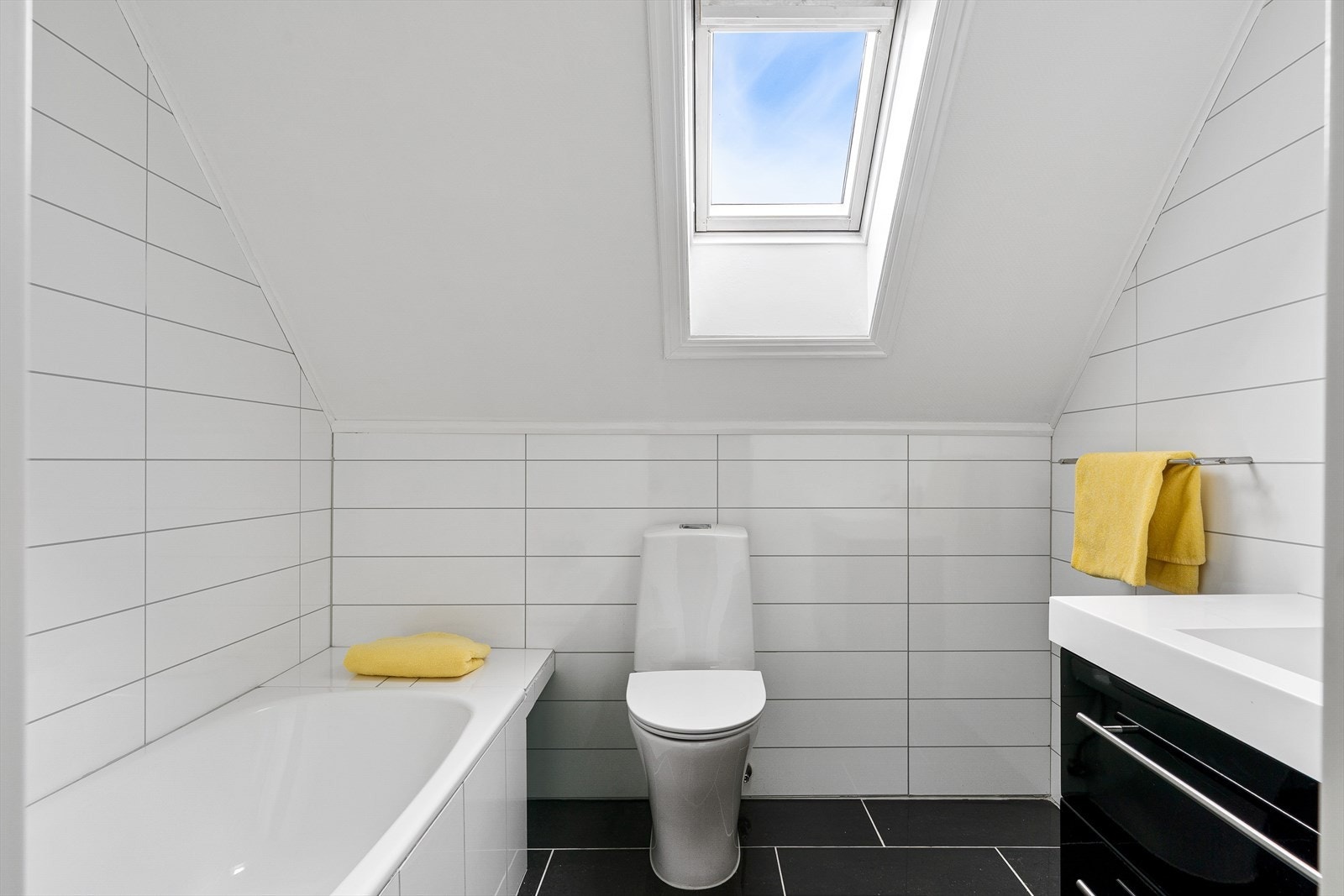 Bad med fliser på gulv og baderomsplater på vegger Galleribilde