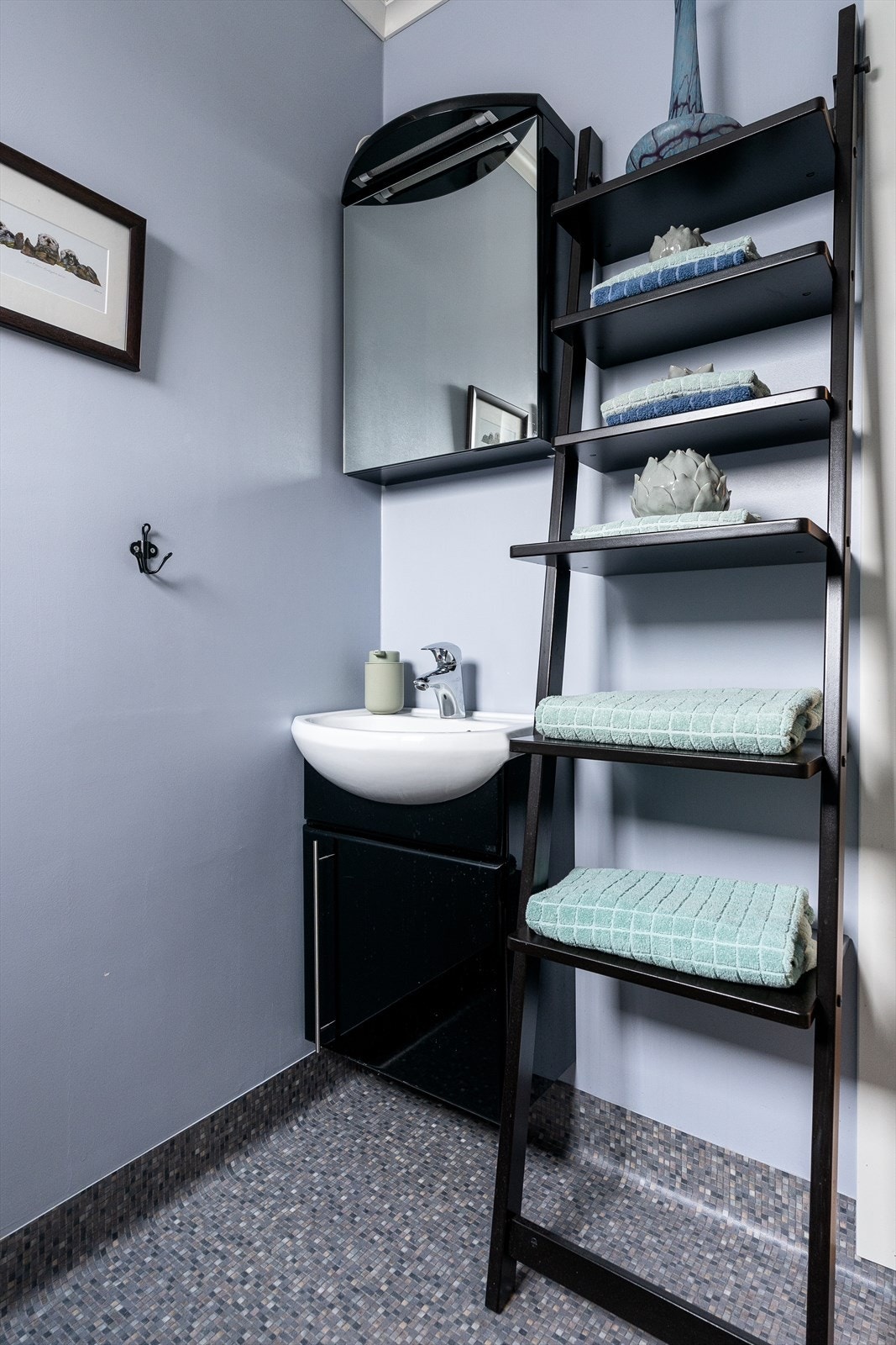 Badet er innredet med vegghengt wc, dusjkabinett og seksjon med vask Galleribilde