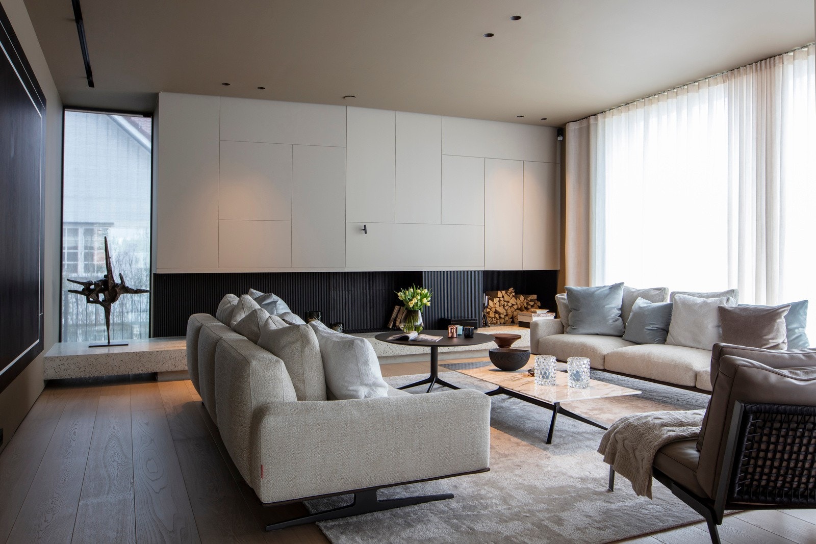 Romslig, lys og samlende stue med et mesterstykke av en peis som brer seg fra vegg til vegg med lys terrazzosokkel og unik og skreddersydd hette. Galleribilde