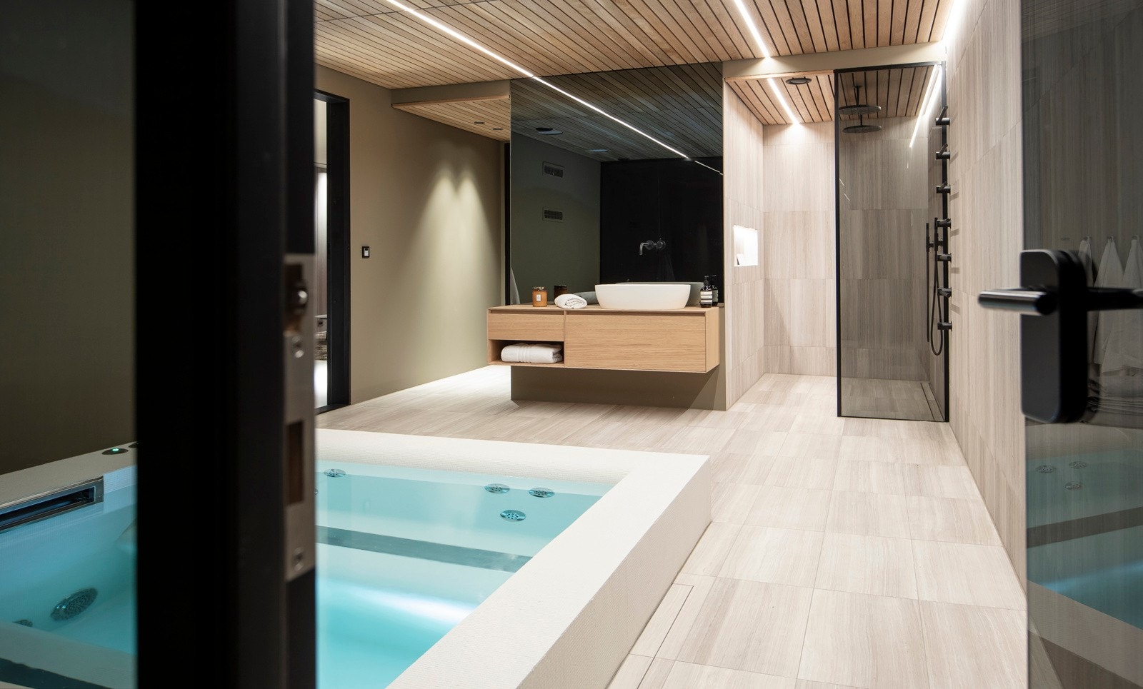 Ved massasjebassenget er det en dusjnisje med to takmonterte regnfallsdusjer, en servantseksjon i eik og et separat wc-rom. Galleribilde