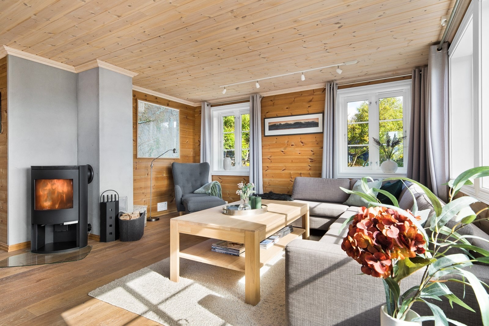 Romslig stue med store vindusflater. En stavs parkett på gulv med varmekabler. Galleribilde