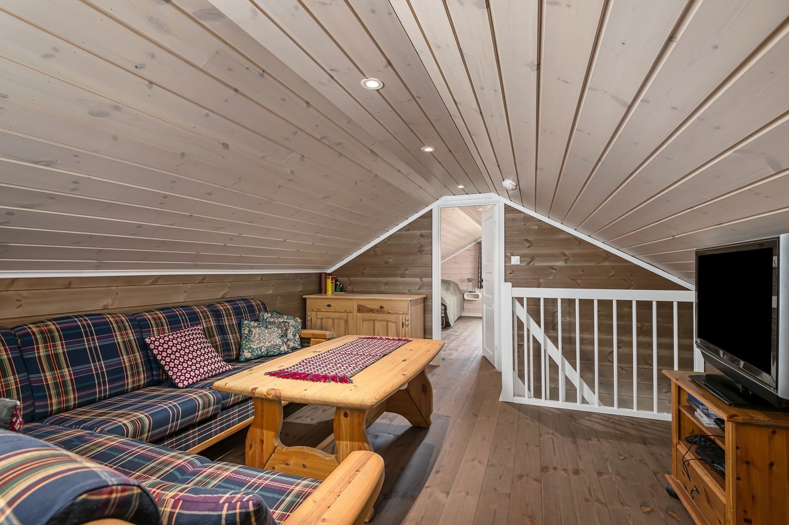 En praktisk loftstue mellom rommene gir verdifull ekstra oppholdsplass når hytta fylles opp med familie og venner. Galleribilde