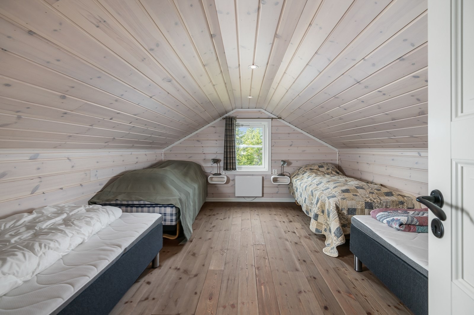 Stort rom i loftetasjen innredet med senger. Galleribilde