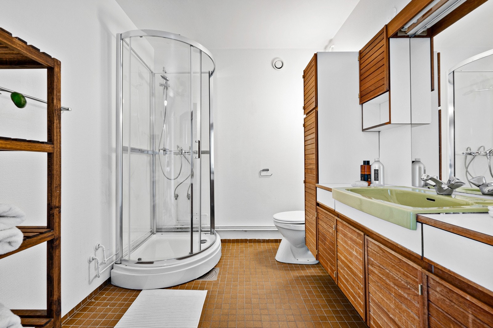 Baderom med fliser på gulv og vegghengt servant. Galleribilde