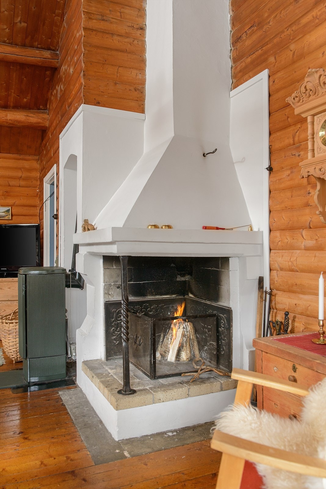 En åpen peis hører med på en slik hytte og kler rommet godt. Galleribilde
