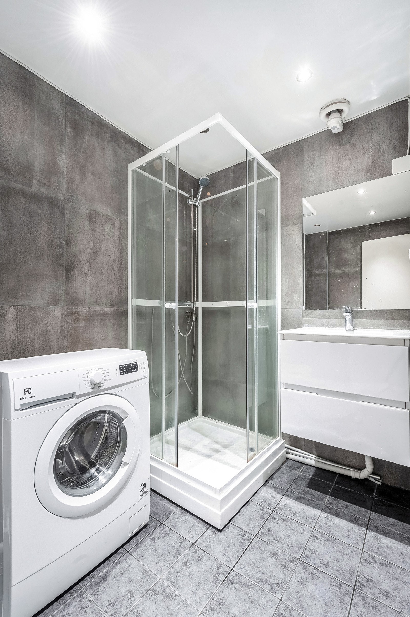 Badet er innredet med servant, dusjkabinett og gulvstående toalett. Galleribilde