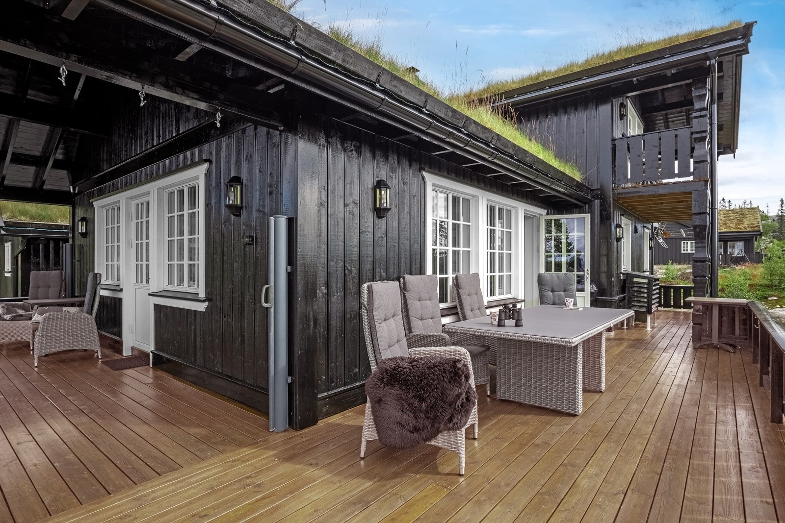 Terrassen strekker seg fra sydenden til vestenden av hytta Galleribilde