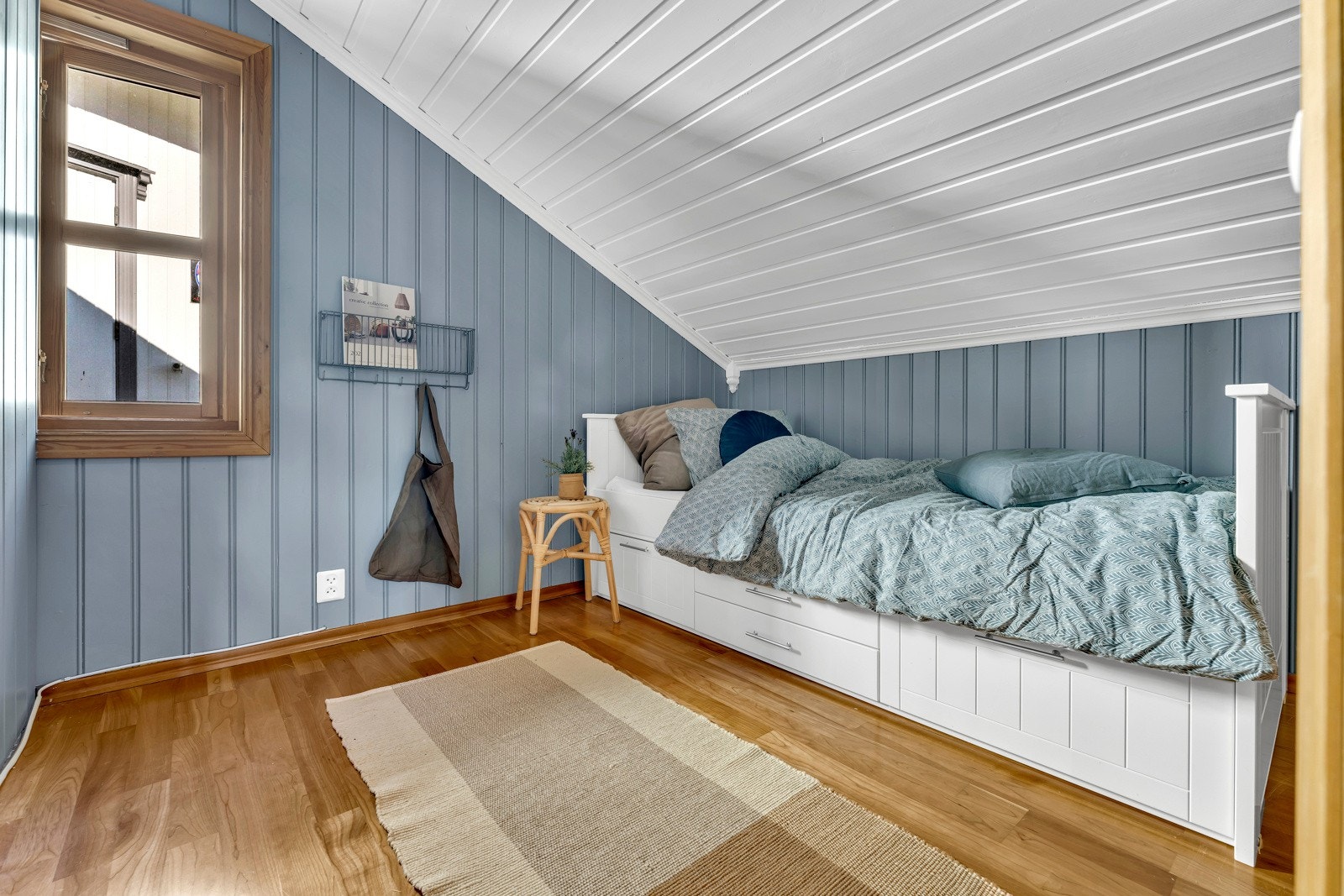 De to andre soverommene på loftet har blåmalte vegger, parkettgulv og hvitmalt panelhimling med downlights. Galleribilde