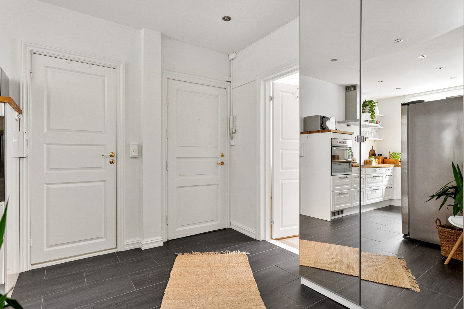 Romslig entre med fliser på gulv, varmekabler og dobbelt garderobeskap. Galleribilde