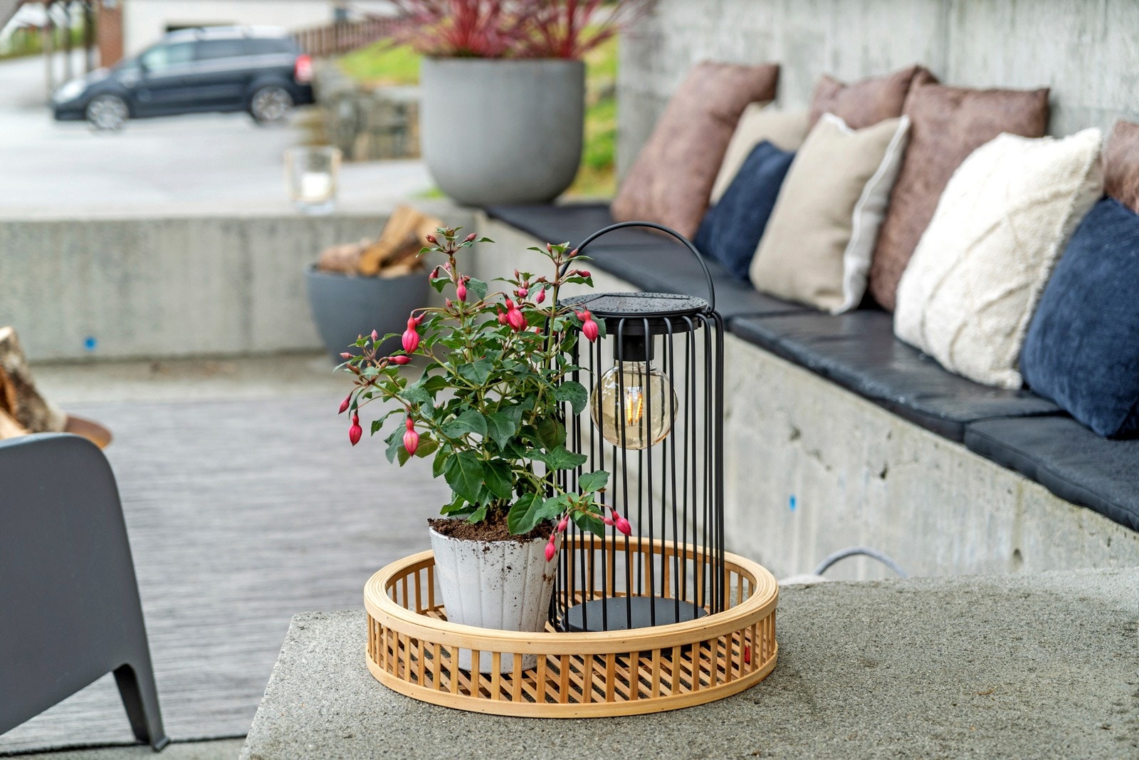 På fremsiden av boligen har man flere oppholdssoner - her er et med stedstøpte sittebenker og ypperlig sted for bålpanne Galleribilde