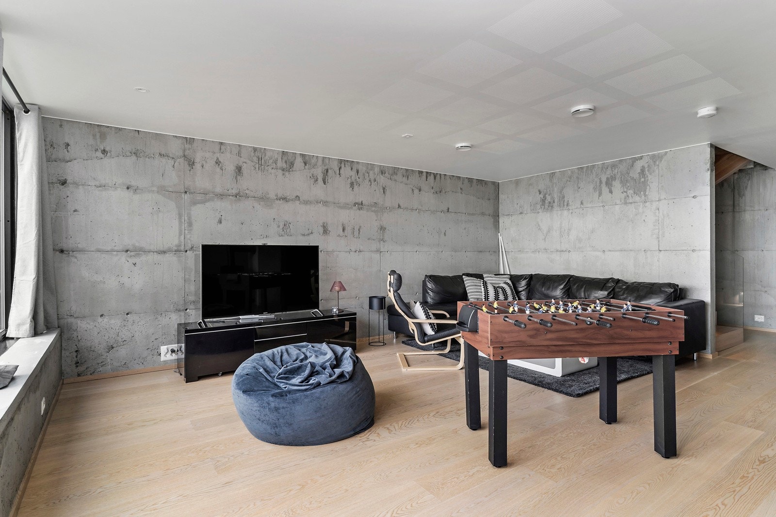 Man har utstrakt bruk av betong på flere vegger og i flere rom som en gjennomgående stil i boligen Galleribilde