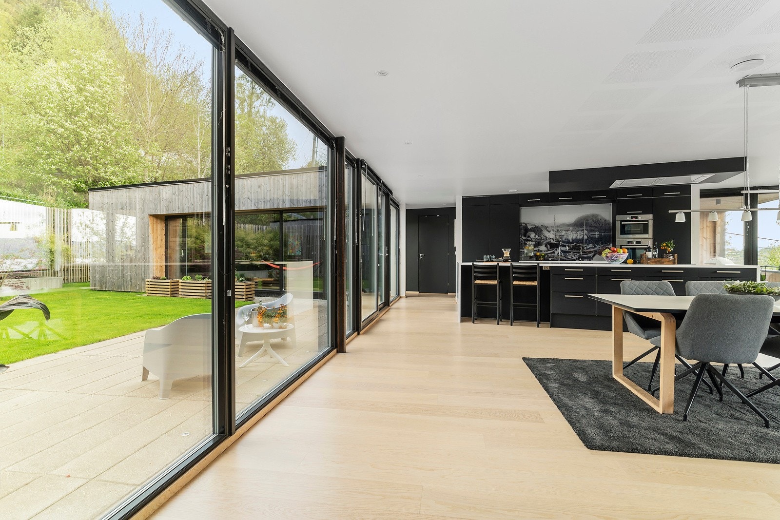 Fra kjøkkenet og spisestuen har man enkel tilkomst til atriumhagen - noe som gjør det enkelt å ta frokosten ute! Galleribilde