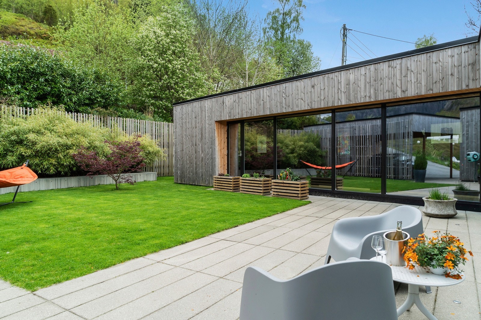 Eiendommen er nokså lettstelt med vedlikeholdsfrie materialer med utstrakt bruk av betong og en kledning av kjerneved som er grånet til en fin sølvfarge. Galleribilde