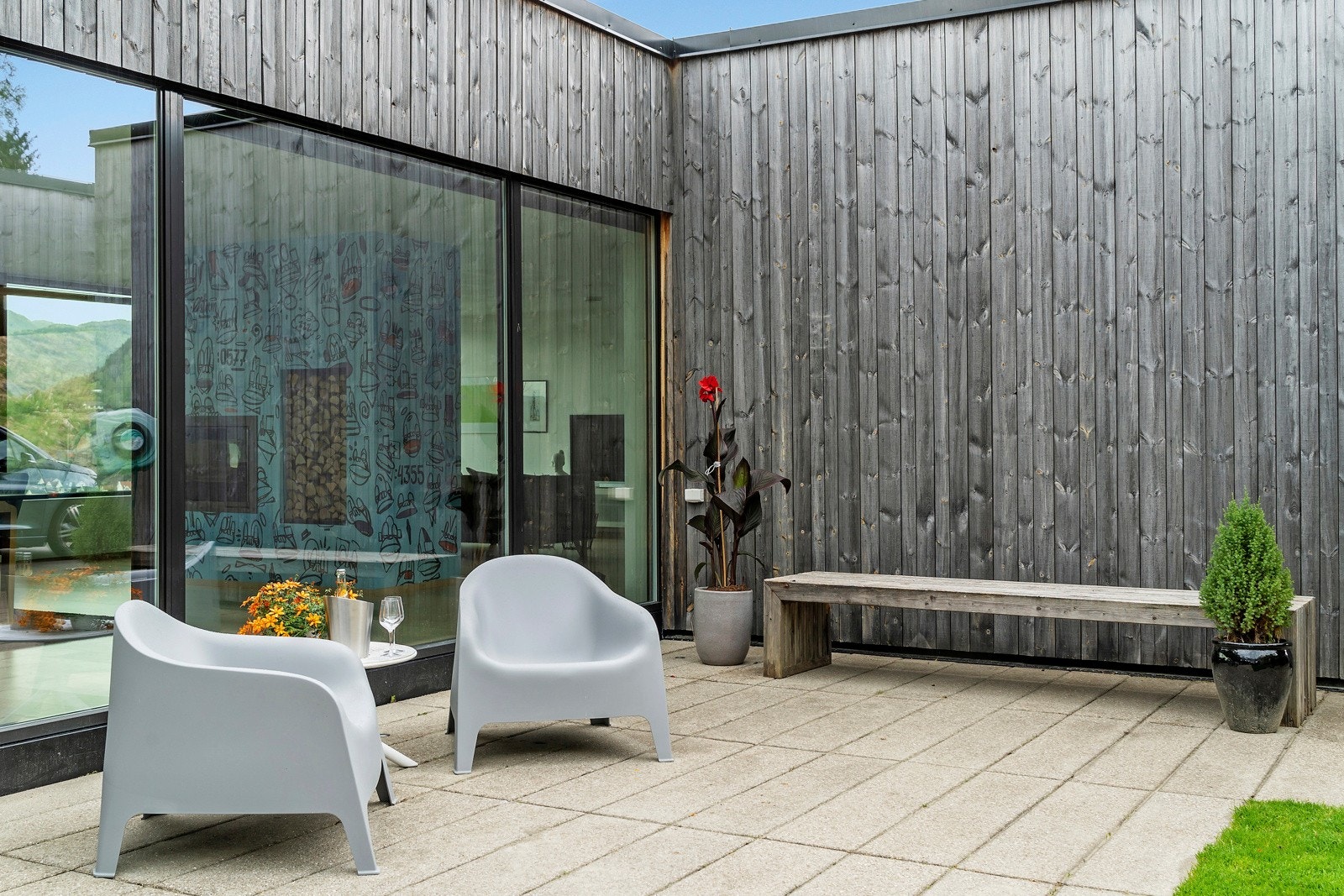 Store glassfelt fra gulv til tak gjør at utsikten kan nytes tvers gjennom stuen og helt inn til atriumshagen Galleribilde