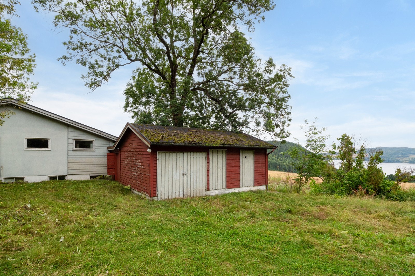 Eiendommen består av en enebolig og et uthus med garasje og boder. Galleribilde