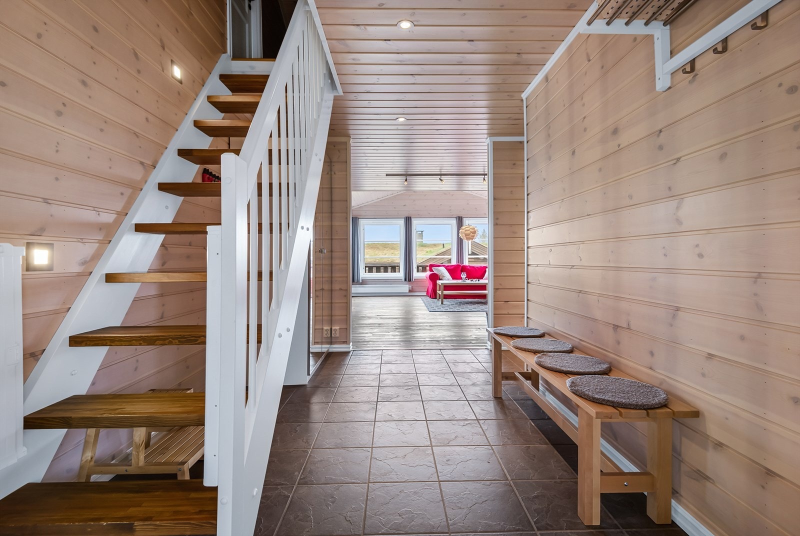 Fra gangen med fin hengeplass for yttertøy og utstyr. Trapp opp til hemsen og åpent inn mot stue/kjøkken. Galleribilde
