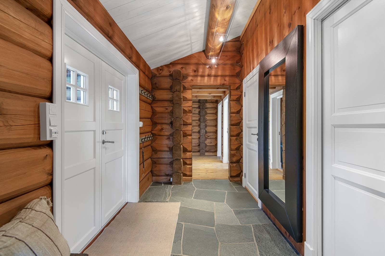 Entré med gode oppbevaringsmuligheter for yttertøy på veggmonterte knaggrekker i rommet. Galleribilde