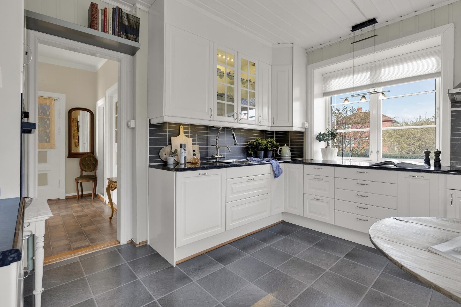 Fra det ene kjøkkenvinduet har man direkte utsikt ut i hagen, så kjøkkenvinduet kan fungere som et slags kioskvindu om sommeren, om man vil servere rett fra kjøkkenet og ut på langbordet. Galleribilde