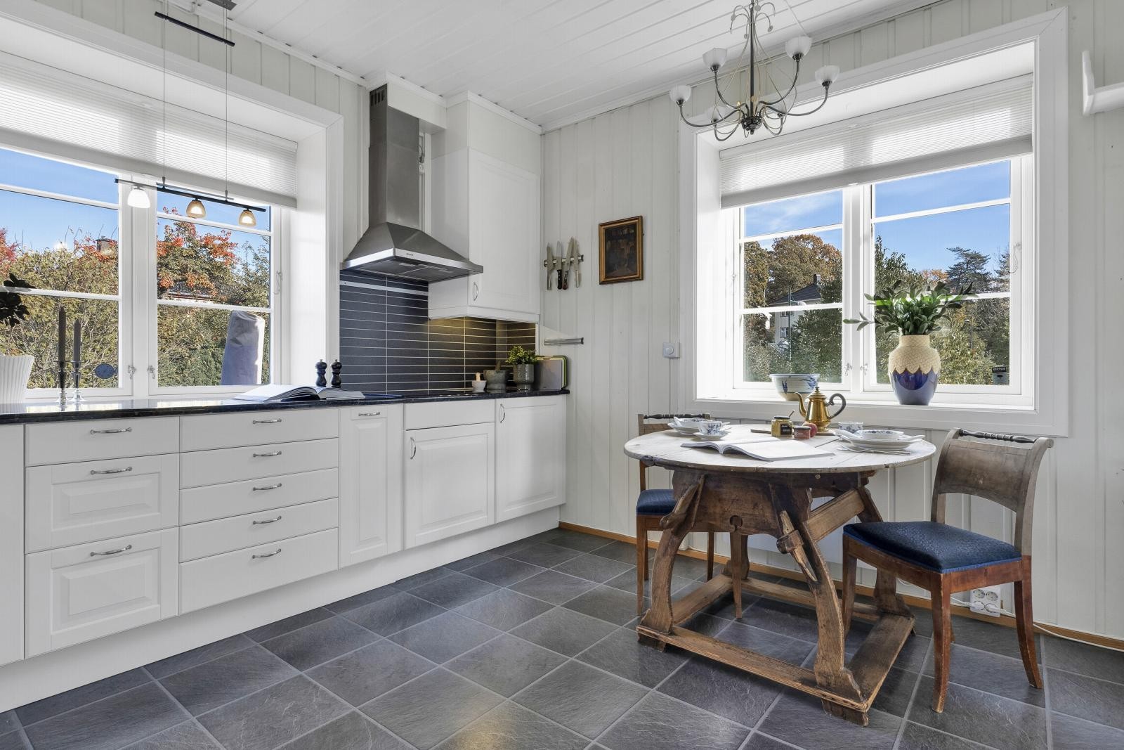 Kjøkkenet er et flott rom med plass til spisebord, perfekt til både hverdager og hyggelige sammenkomster. Store vindusflater på to sider gir herlige lysforhold på kjøkkenet. Galleribilde