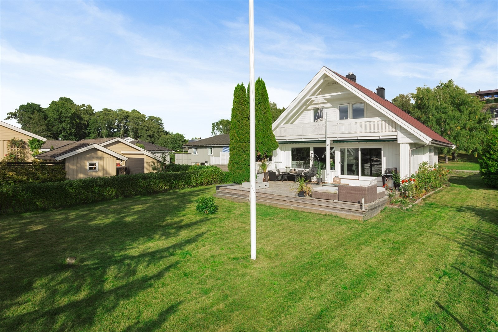 Tomten er pent opparbeider med plen og beplantning. Galleribilde