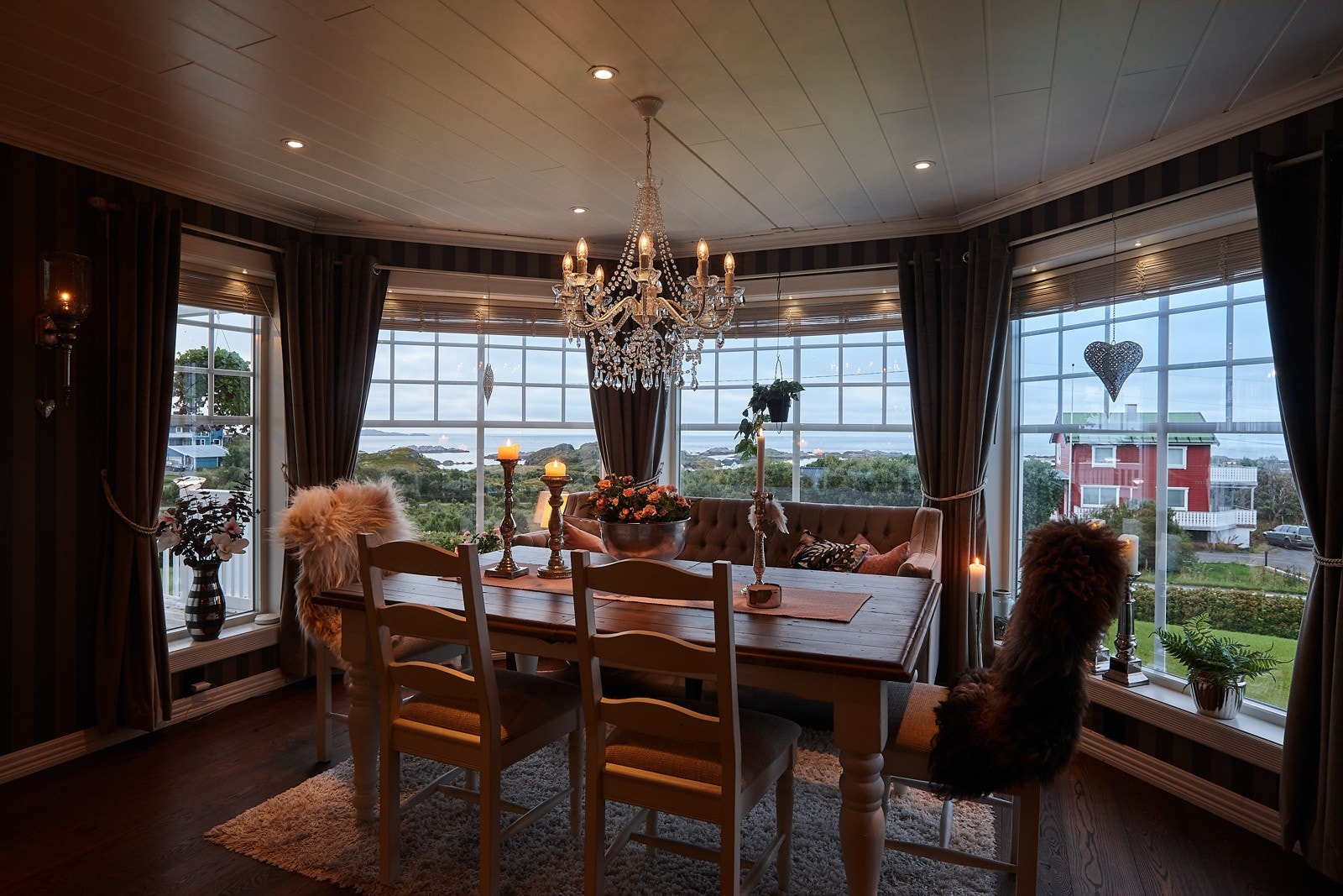 Spisestue med store vindusflater. Verdt å merke seg at det i tillegg er lysspotter i alle vinduskarmer. Galleribilde