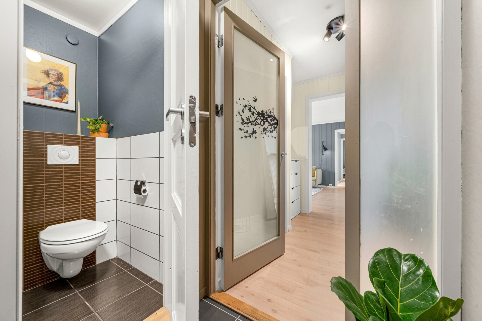 Toalettrommet har flis på gulv og vegghengt WC. Galleribilde