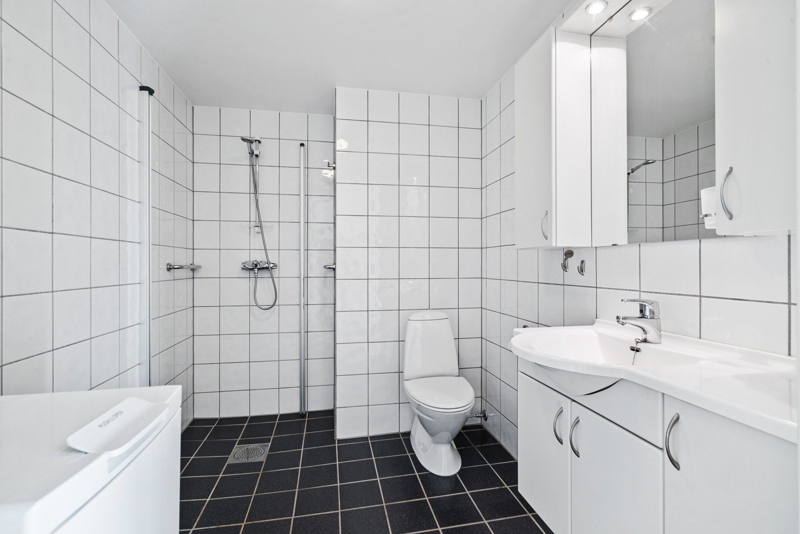 Lyst og delikat flislagt bad med behagelig gulvvarme og ferdig opplegg for vaskemaskin Galleribilde