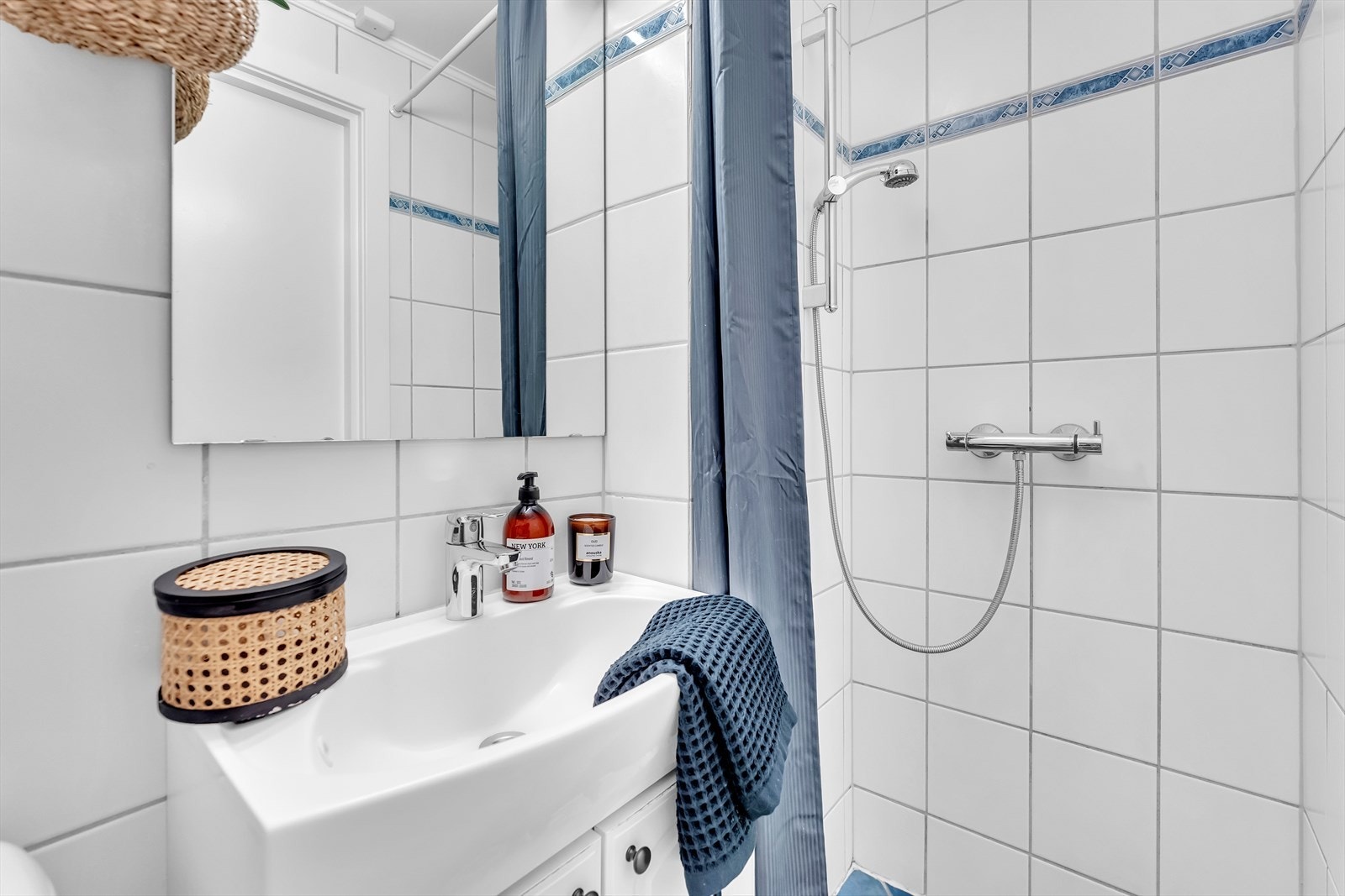 Flislagt baderom med dusjhjørne, innvending med servant, samt toalett. Galleribilde