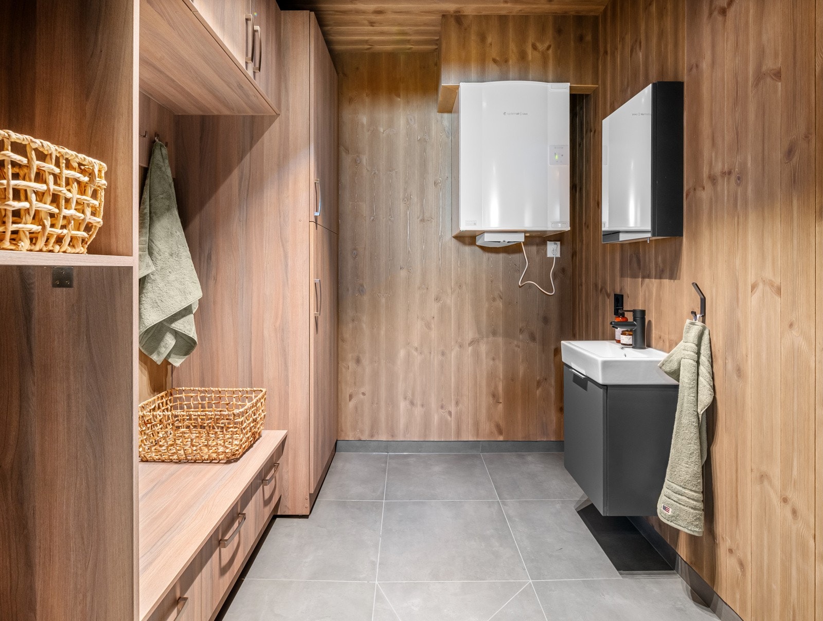 Leiligheten har et praktisk vaskerom med flislagt gulv med gulvvarme og plassbygget garderobe. Vaskerommet har opplegg for vaskemaskin og vegghengt toalett. Galleribilde