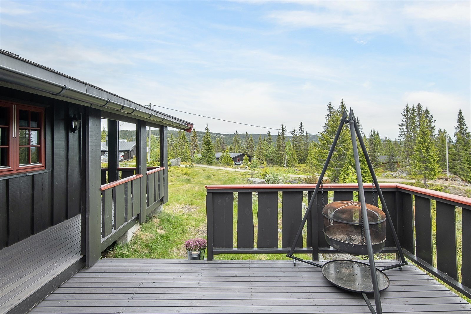 Romslig, delvis overbygget terrasse i forbindelse med inngangsparti. Det er to innganger til hytta. Galleribilde